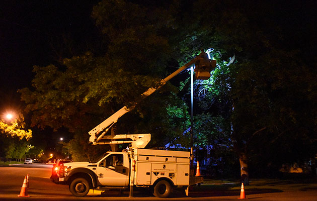 A line worker replaces an LED streetlight.